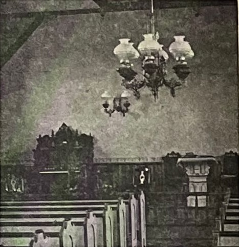 Historic interior of Wevertown Methodist Church showing ornate chandelier, wooden pews, and traditional sanctuary layout from 1800s